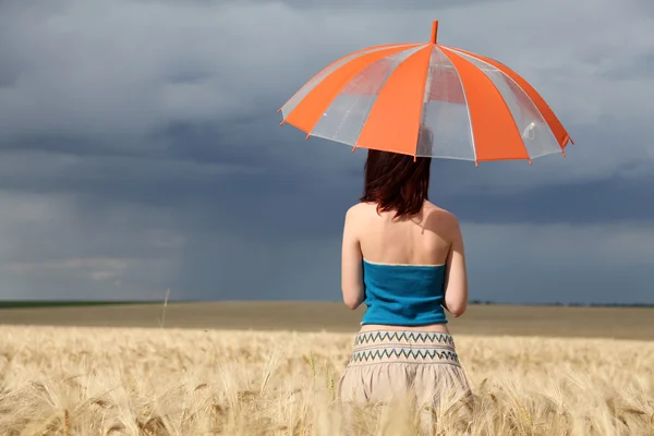 Девушка с зонтиком на поле в дождливый день . — стоковое фото