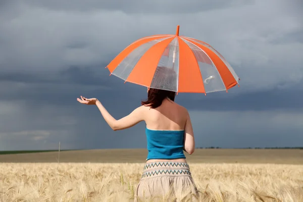 Menina com guarda-chuva no campo em dia chuvoso . — Fotografia de Stock