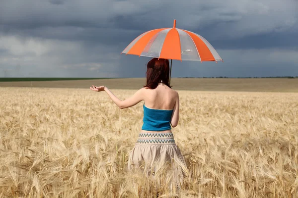 Flicka med paraply på fältet i regnig dag. — Stockfoto
