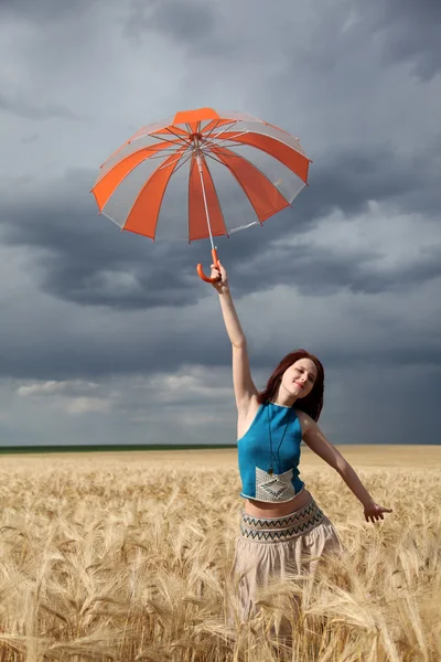 Mädchen mit Regenschirm auf Feld bei Regen. — Stockfoto