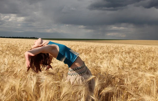 Mooi meisje op tarwe field in regenachtige dag — Stockfoto