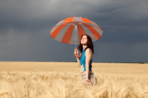 Dívka s deštníkem na hřišti v deštivý den. — Stock fotografie