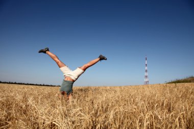 Acrobatic girl at field near radio antenna clipart