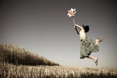 Girl with toy wind turbine at field, photo in age style clipart