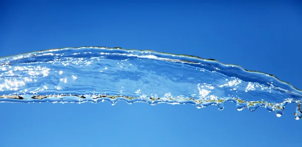 Wasserspritzer isoliert auf blau. — Stockfoto