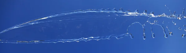 Vatten stänk isolerad på blå. — Stockfoto