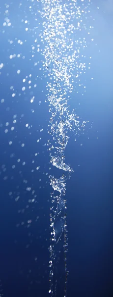 Wasserspritzer isoliert auf blau. — Stockfoto