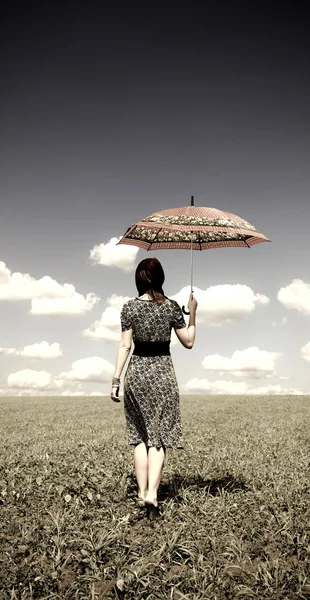 Girl with umbrella at green grass field in sunny day. — Stock Photo, Image