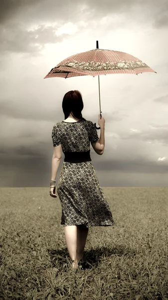 Menina com guarda-chuva no campo de grama verde em dia ensolarado . — Fotografia de Stock