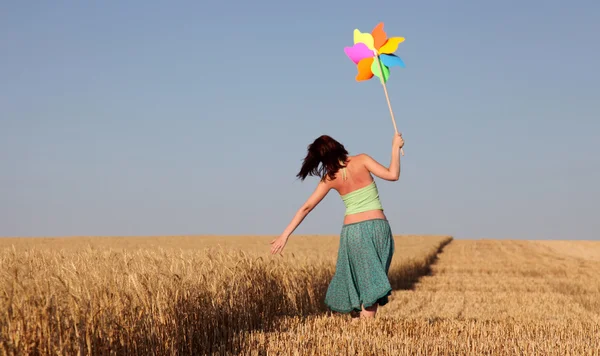 Meisje met windturbine op tarweveld — Stockfoto