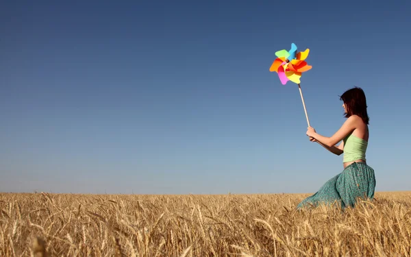 Menina com turbina eólica no campo de trigo — Fotografia de Stock
