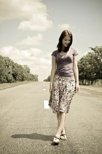 Chica caminando a pie en la carretera en estilo vintage — Foto de Stock