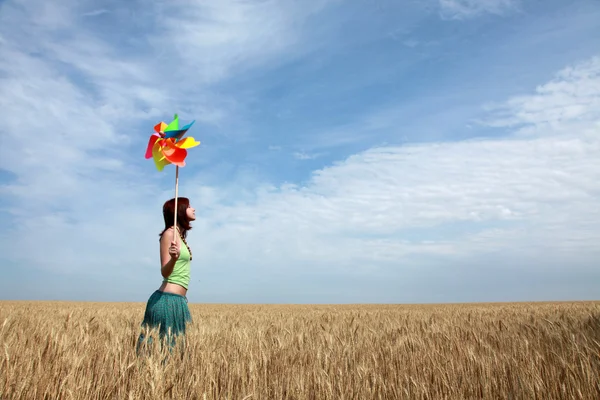 Chica con turbina eólica en campo de trigo — Foto de Stock