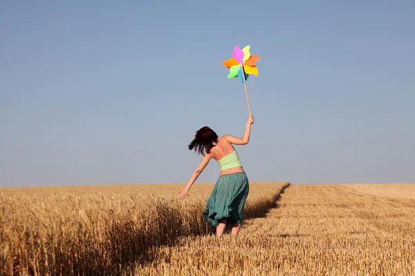 Menina com turbina eólica no campo de trigo — Fotografia de Stock