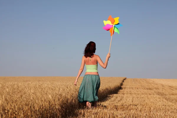 Dziewczyna z turbiną wiatrową na polu pszenicy — Zdjęcie stockowe