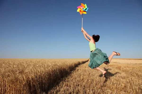 Flicka med vindkraftverk på vetefält — Stockfoto