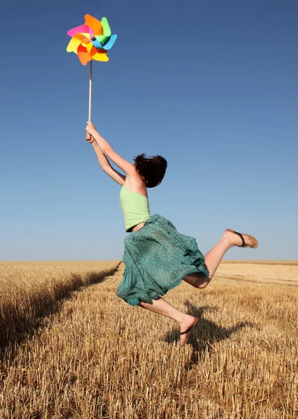 Дівчина з вітряною турбіною на пшеничному полі — стокове фото