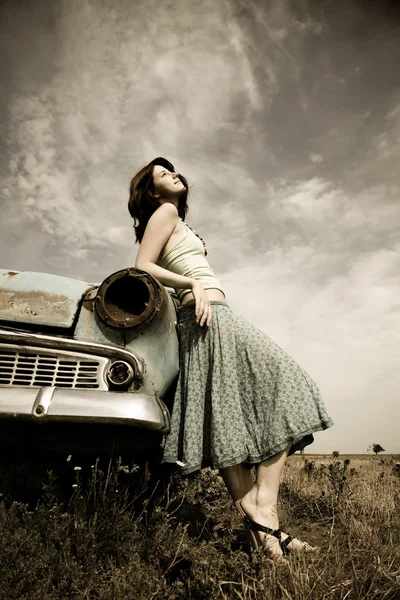 Meisje in de buurt van oude auto, foto in vintage stijl — Stockfoto