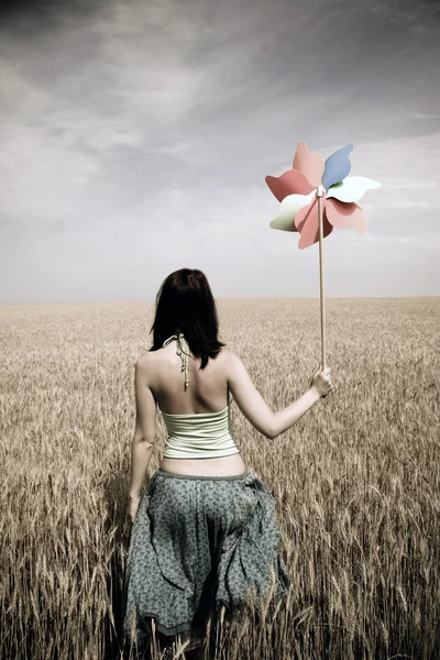Dívka s hračkou větrnou turbínu na poli, Foto ve stáří stylu — Stock fotografie