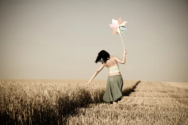Chica con aerogenerador de juguete en el campo, foto en estilo de edad — Foto de Stock