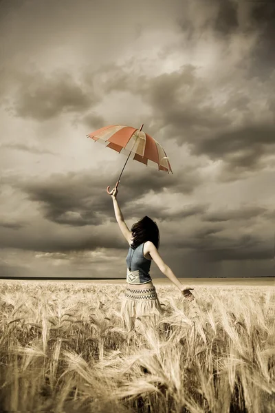 Meisje met paraplu op veld in retro stijl — Stockfoto