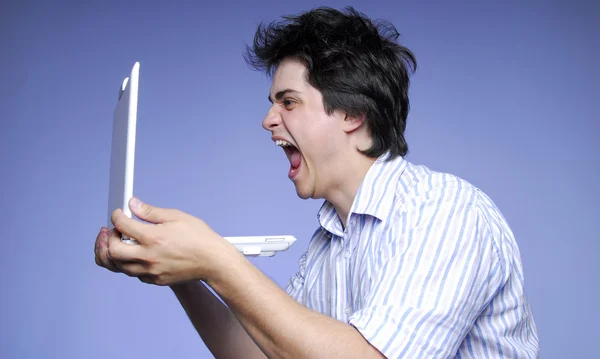 Garçon en colère avec ordinateur portable dans les mains . — Photo