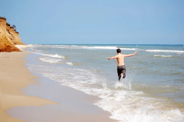 Σωματικά ικανός άνθρωπος που τρέχει στην παραλία. — Φωτογραφία Αρχείου