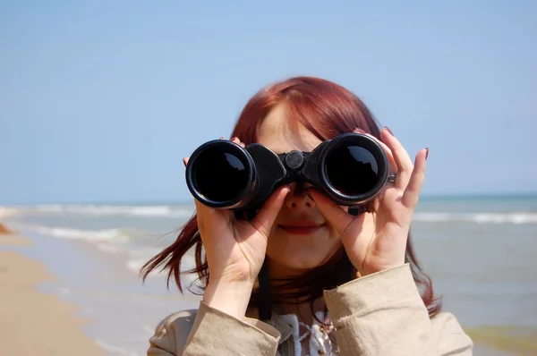 Menina com binocular na praia . — Fotografia de Stock