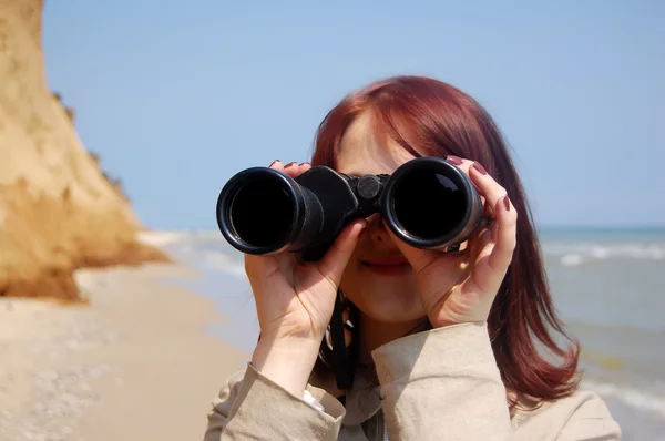 Chica con binocular en la playa . — Foto de Stock
