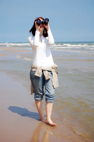 Ragazza con binocolo in spiaggia . — Foto Stock