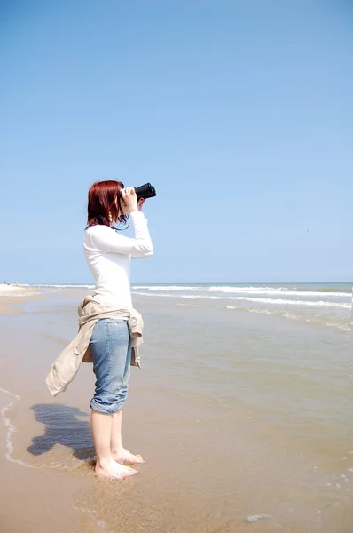 Girl with binocular at beach. — Stock Photo, Image
