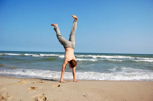 Akrobatiska män på stranden. — Stockfoto