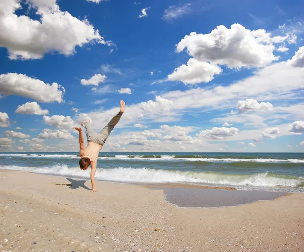 Akrobatischer Junge am Strand — Stockfoto