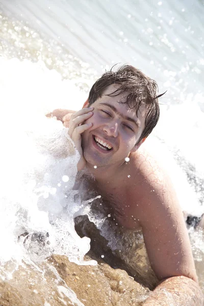 Mladý, usměvavý lidé na vlny na pláži. — Stock fotografie