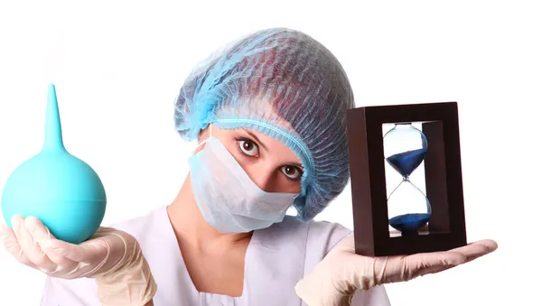 Sjuksköterska med clyster och timglas — Stockfoto