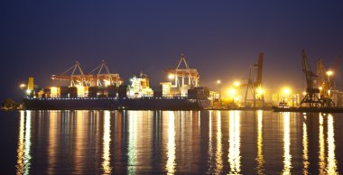Cargo ship in the port at night clipart