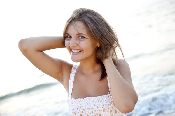 Pretty young woman standing on beach — Stock Photo, Image