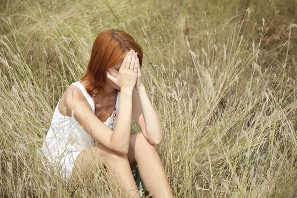 Çimen üzücü Kızıl saçlı kız. — Stok fotoğraf