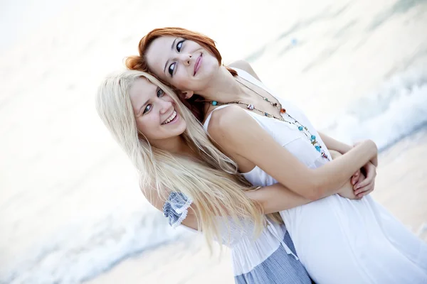 Two beautiful young girlfriends on the beach — Stock Photo, Image