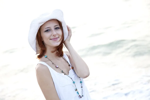 Bella giovane ragazza dai capelli rossi in cappello sulla spiaggia — Foto Stock