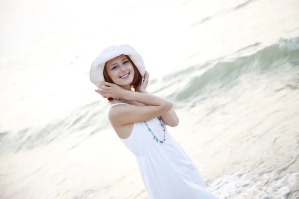 Menina bonita de cabelos vermelhos no chapéu na praia — Fotografia de Stock