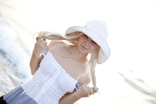 在海滩上的帽子美丽年轻的金发女郎 — 图库照片