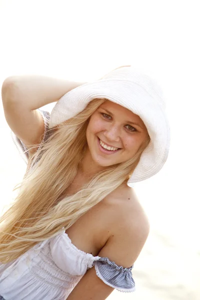Mooie blonde meisje in de hoed op het strand — Stockfoto