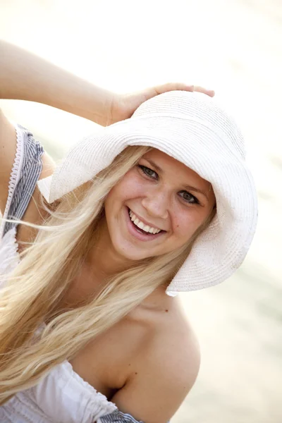 Schöne junge blonde Mädchen mit Hut am Strand — Stockfoto