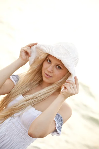 Piękna blondynka dziewczyna w kapeluszu na plaży — Zdjęcie stockowe