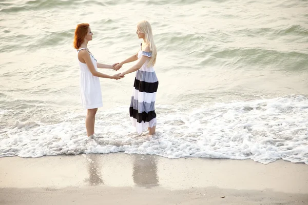 Twee mooie jonge meisjes op het strand — Stockfoto