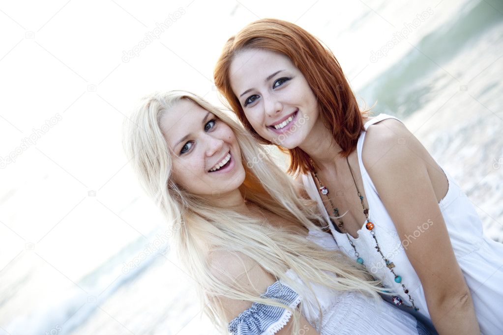Two beautiful young girlfriends on the beach