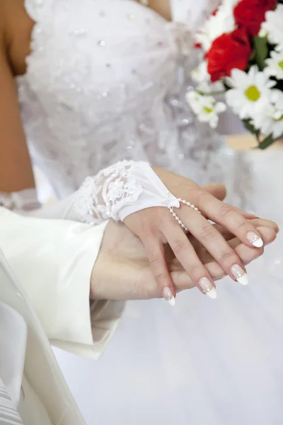 Bridegroom keeping bride hand and beautiful red roses wedding fl — Stock Photo, Image