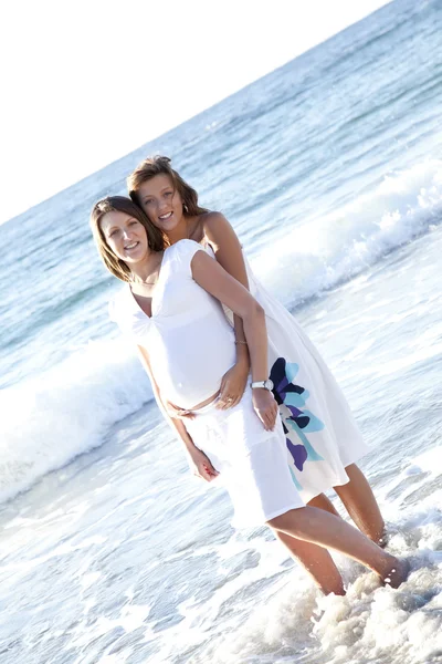 Twee grappige zusters op het strand. — Stockfoto