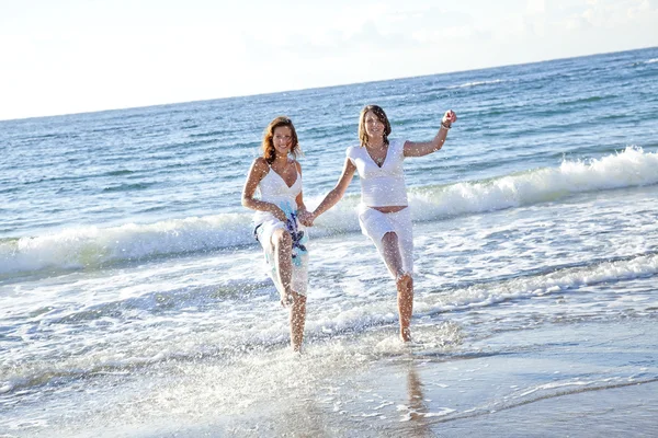 Två funny systrar på stranden. — Stockfoto